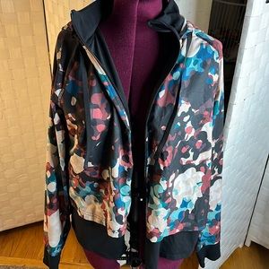 Xersion zip up hooded running jacket. Multi color print and black. L